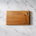 Wooden cutting board with engraved design on a marble surface