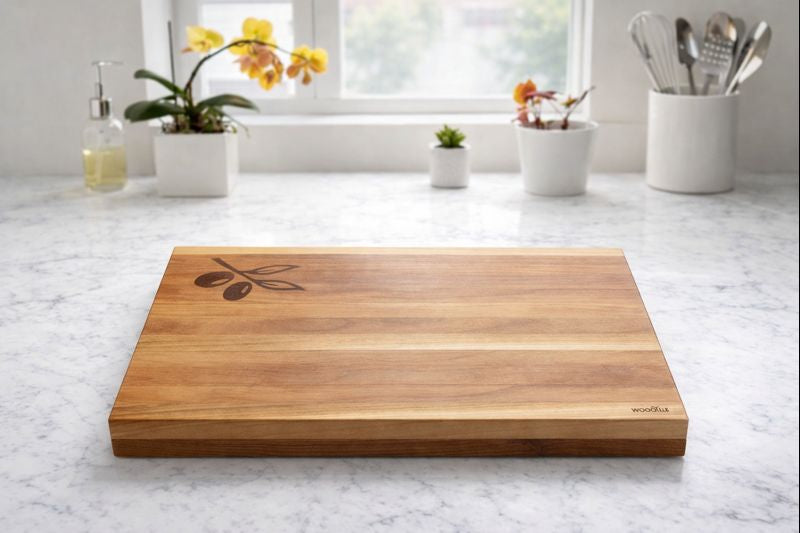Wooden cutting board with olive design on a marble countertop