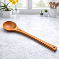 Wooden spoon on a marble countertop with a kitchen background