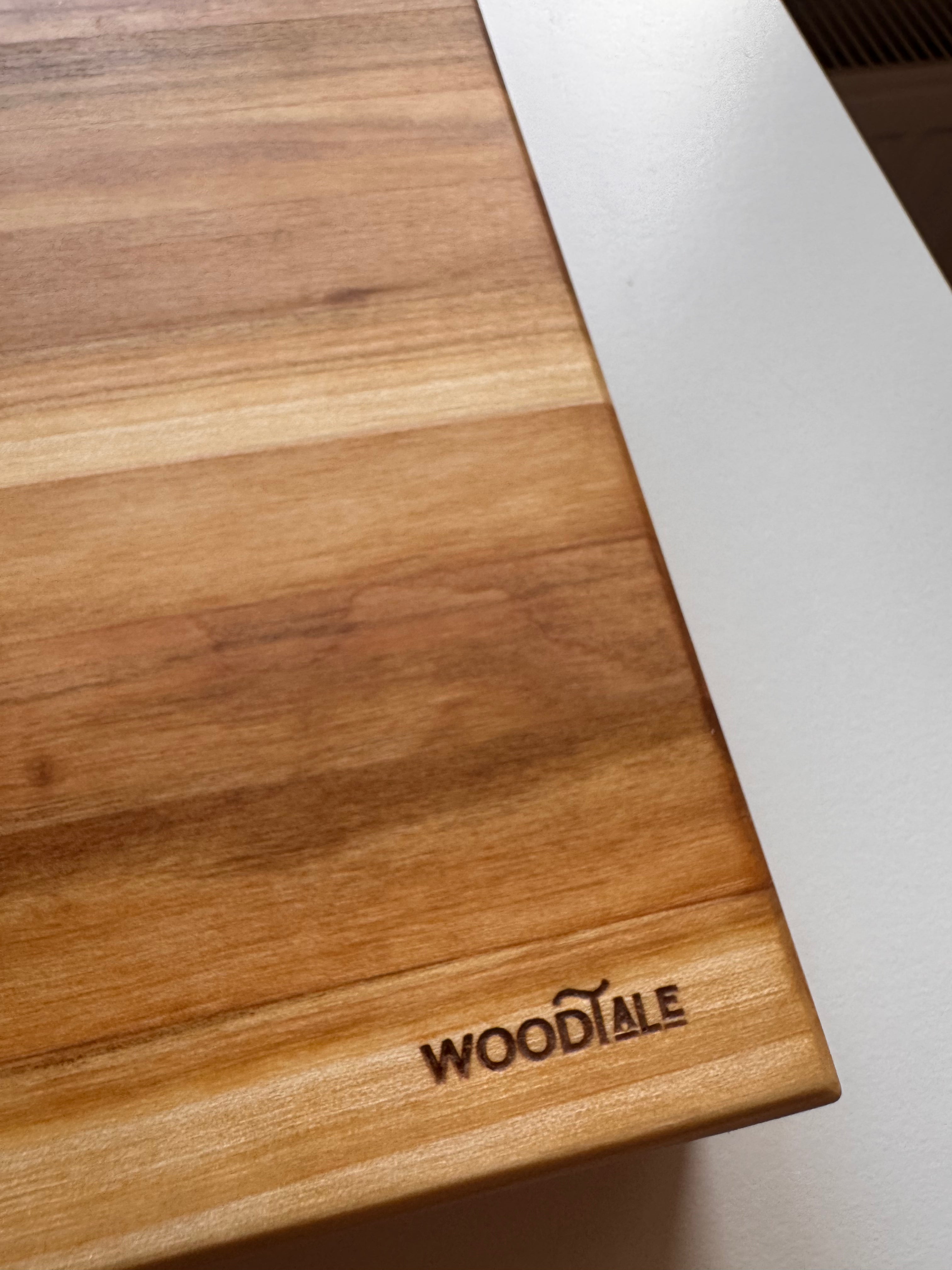 Wooden cutting board with 'WOODTALE' branding on a white surface
