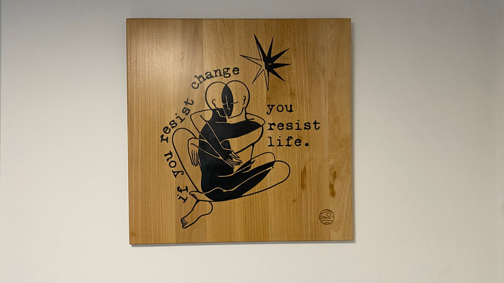 Wooden plaque with black text and graphic on a light gray background