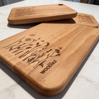 Wooden cutting boards with engraved designs on a marble surface