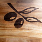Wooden surface with a laser-engraved olive branch design