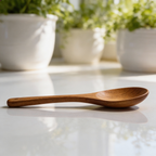 Wooden spoon on a white surface with potted plants in the background